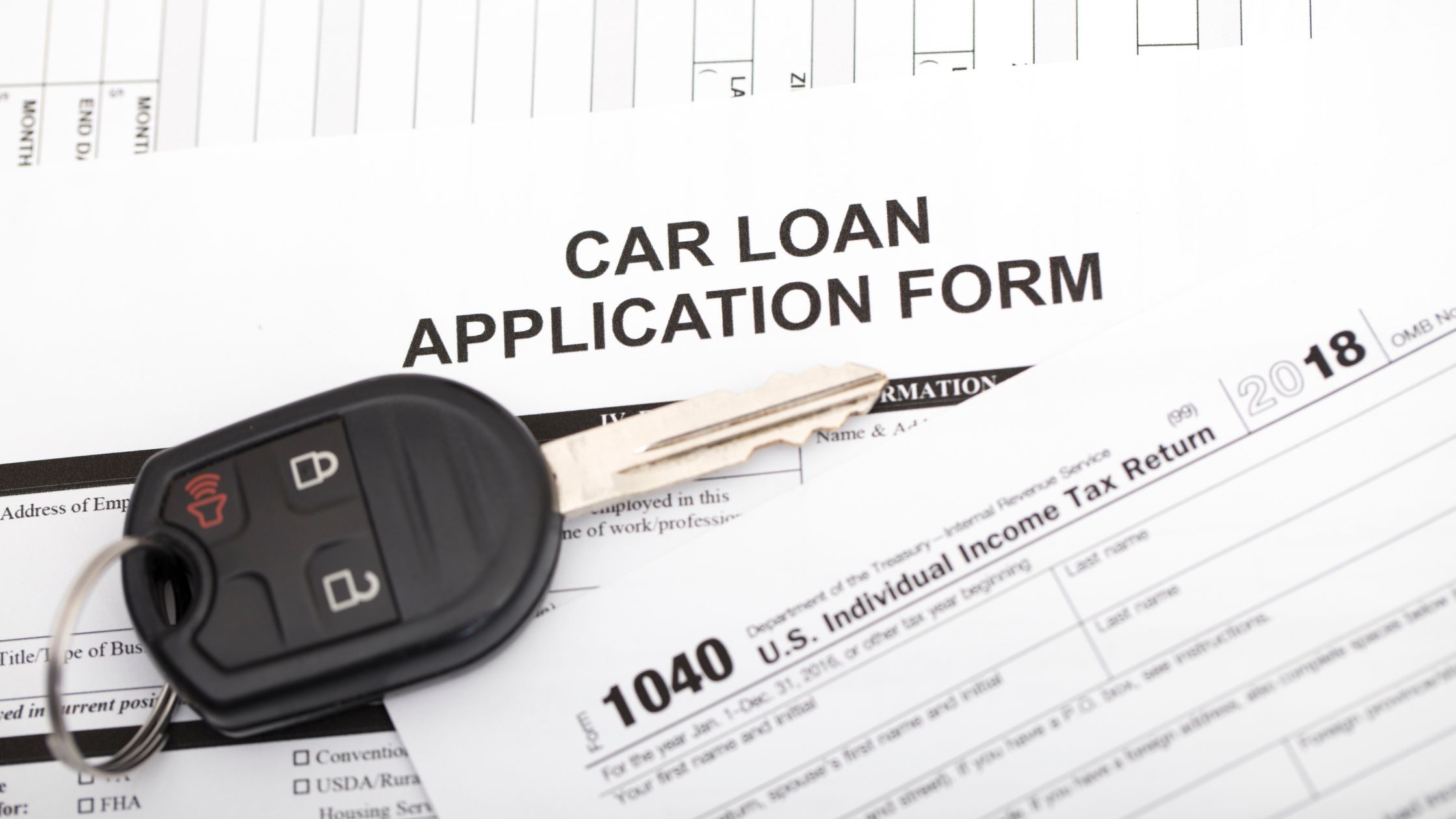 paper saying car loan application with keys on top