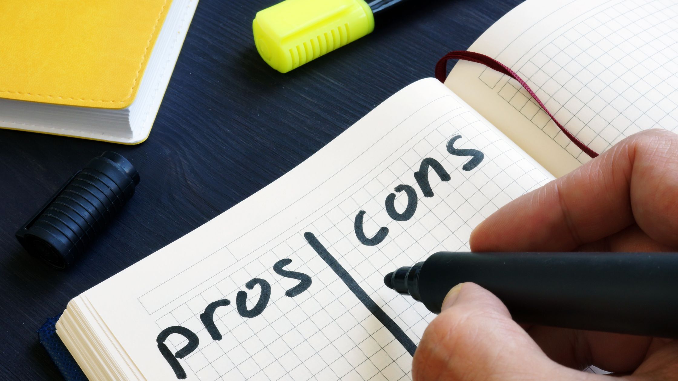 notebook with pros and cons written in marker