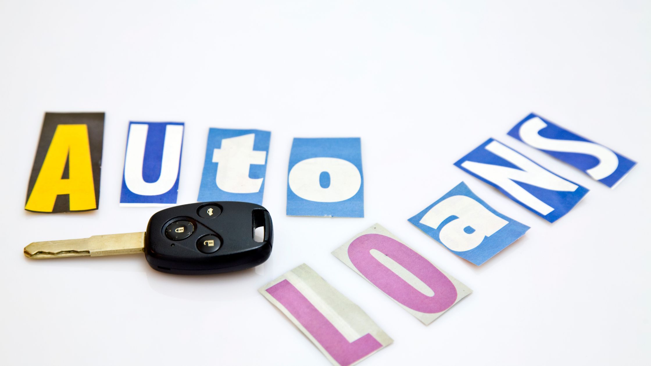 car key next to letters cut out that spell auto loans